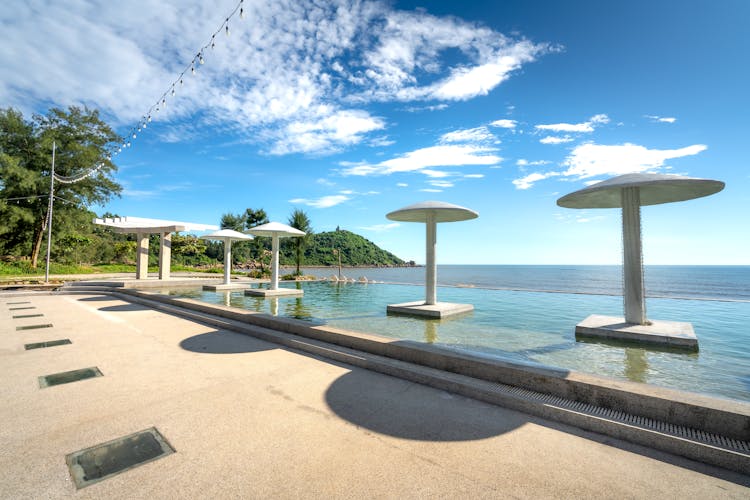 Swimming Pool And Umbrellas On A Tropical Shore