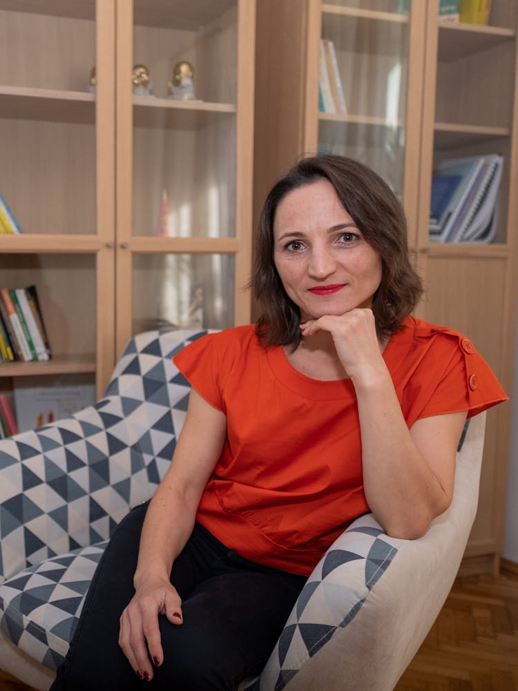 Woman In Red Top Sitting On An Armchair