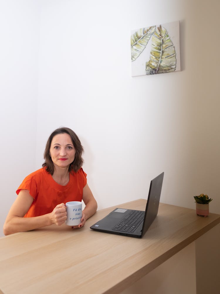 A Woman Sitting While Holding A Mug 