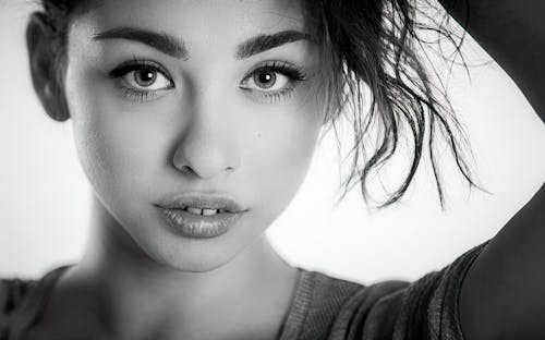 Dramatic black and white portrait of a beautiful lonely girl with freckles isolated on a white