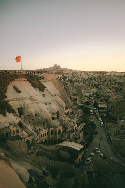 A stunning aerial shot of Göreme, Cappadocia at sunset, showcasing unique rock formations and vibrant colors.