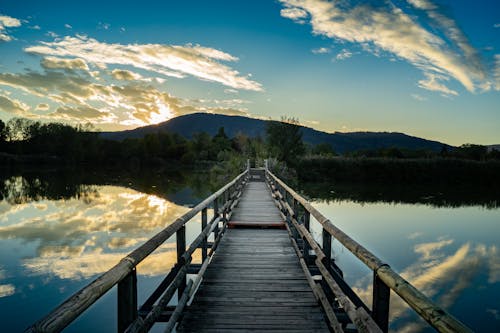 Wooden Footbridge on Lake at Sunset