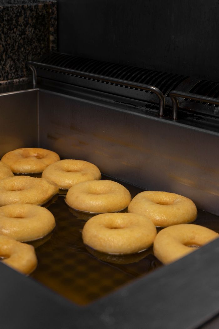 Doughnuts frying in a commercial fryer