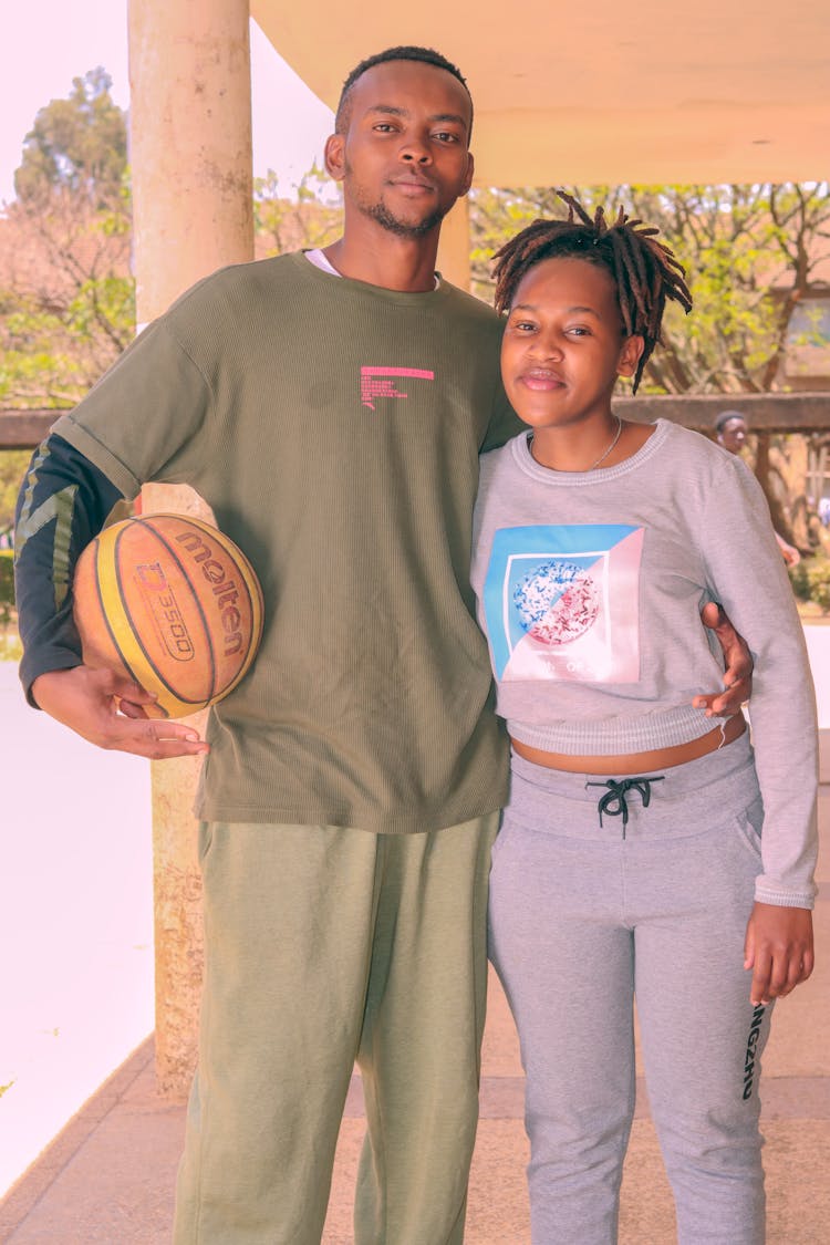 Young Couple In Sportswear And A Basketball