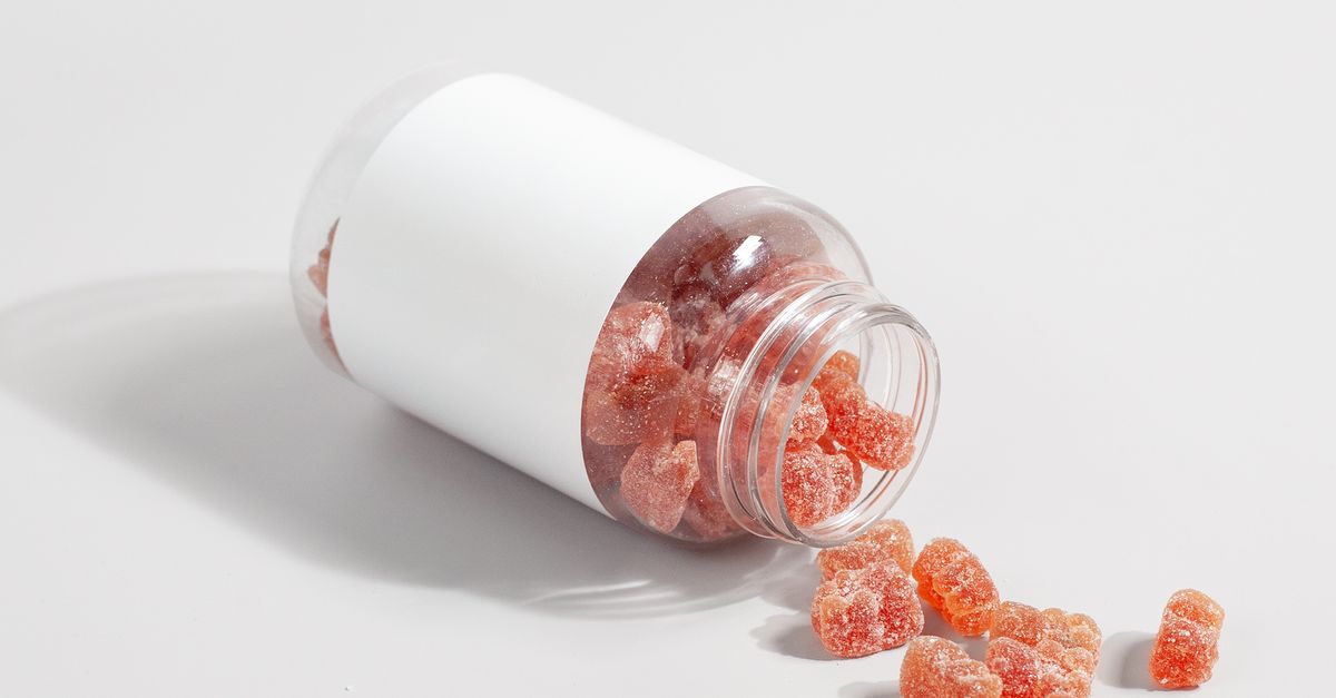 Close-up of gummy vitamins spilled from a clear bottle on a white surface Close-up of gummy vitamins spilled from a clear bottle on a white surface