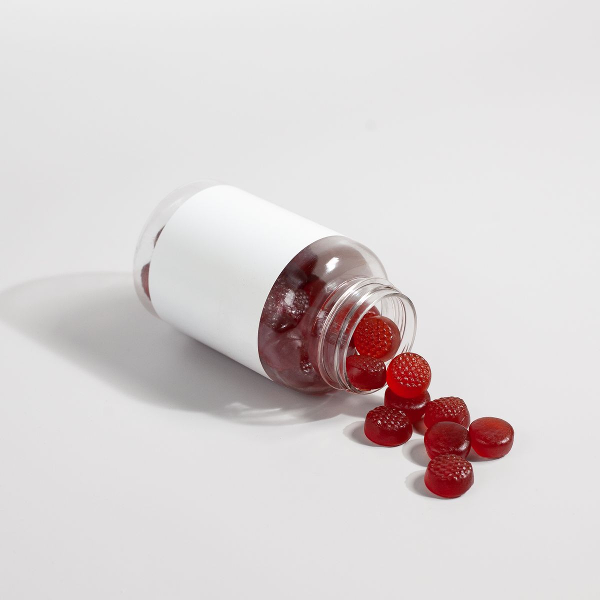 Supplement gummies spilling out of a bottle
