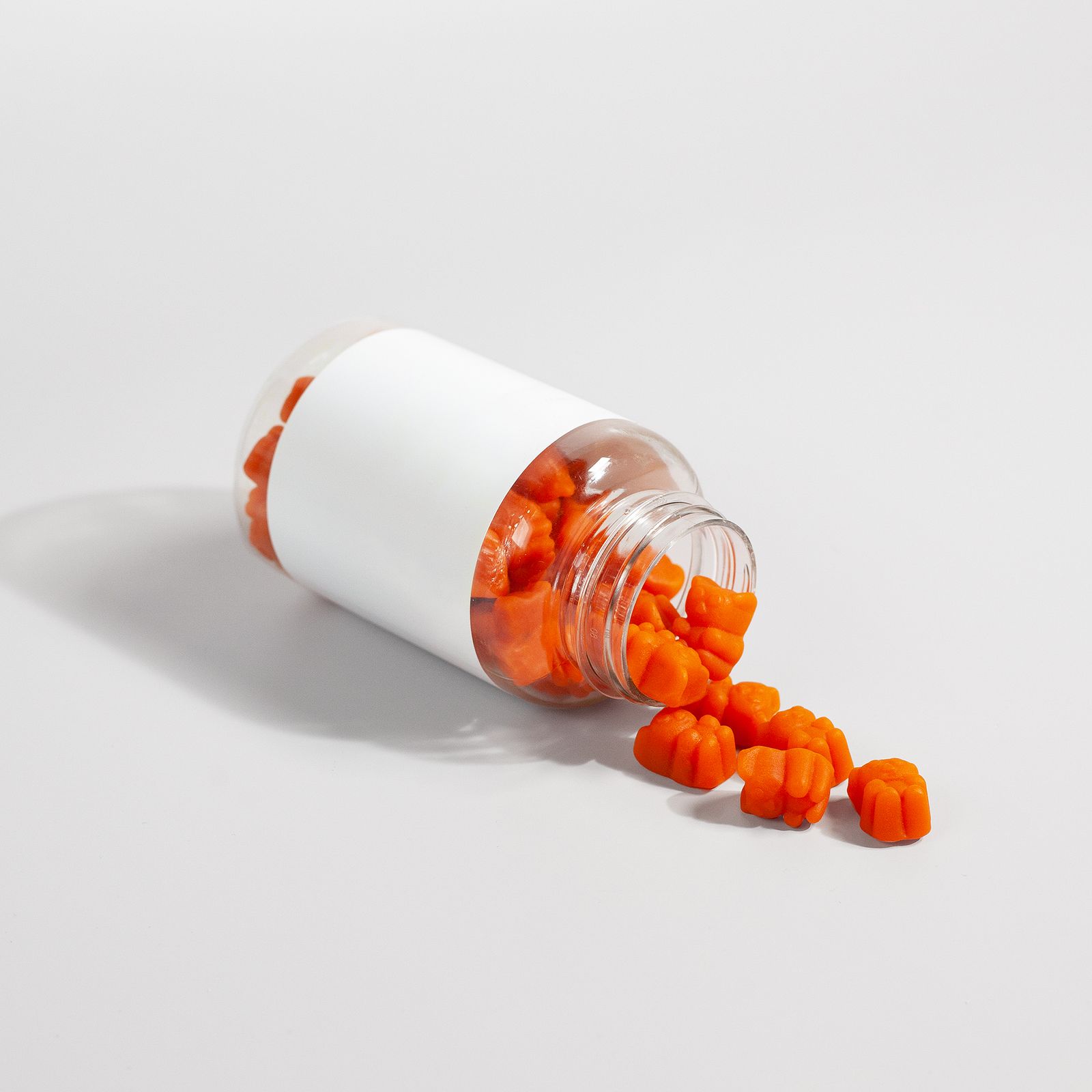 Fiber gummy supplements spilling from a bottle, the kind of daily fiber format women over 40 are choosing between