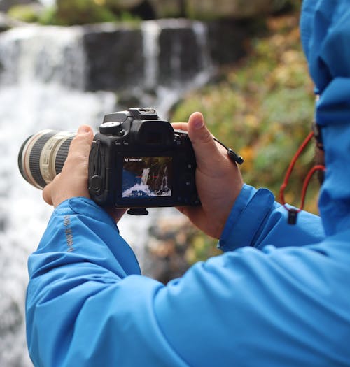 A Person in Blue Jacket Holding Black Camera