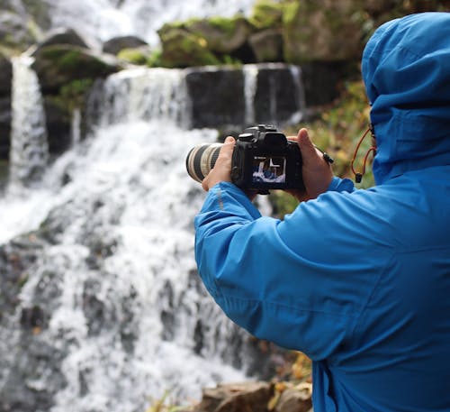 Man in Blue Hoodie Holding Black Dslr Camera