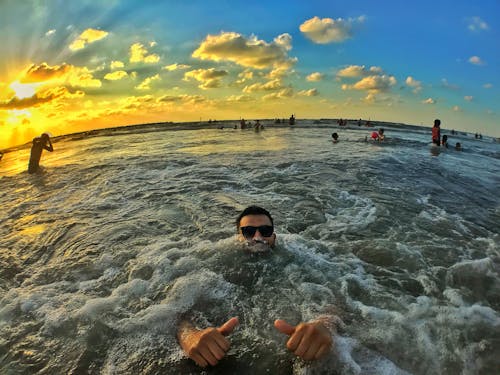 Photography of People on Ocean During Dawn