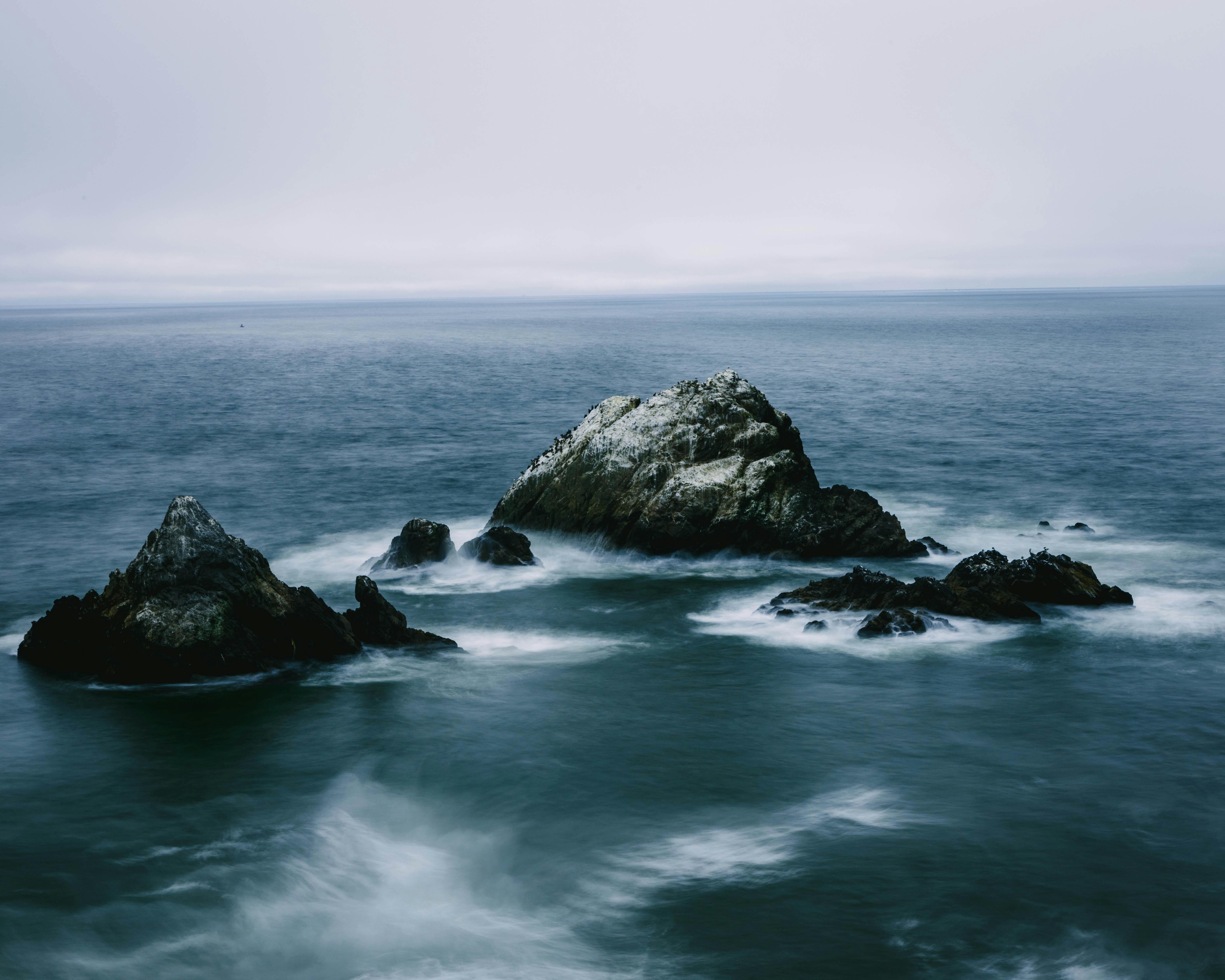 平静的长时间曝光拍摄的海浪轻轻地拥抱岩石露头