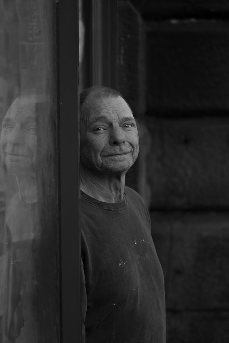 Smiling Man Leaning On The Door Frame