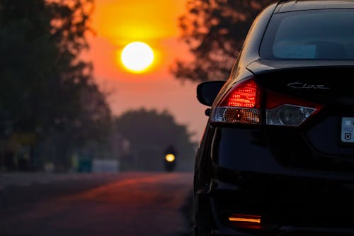 Black Suzuki Ciaz Parked on Roadside During Sunrise