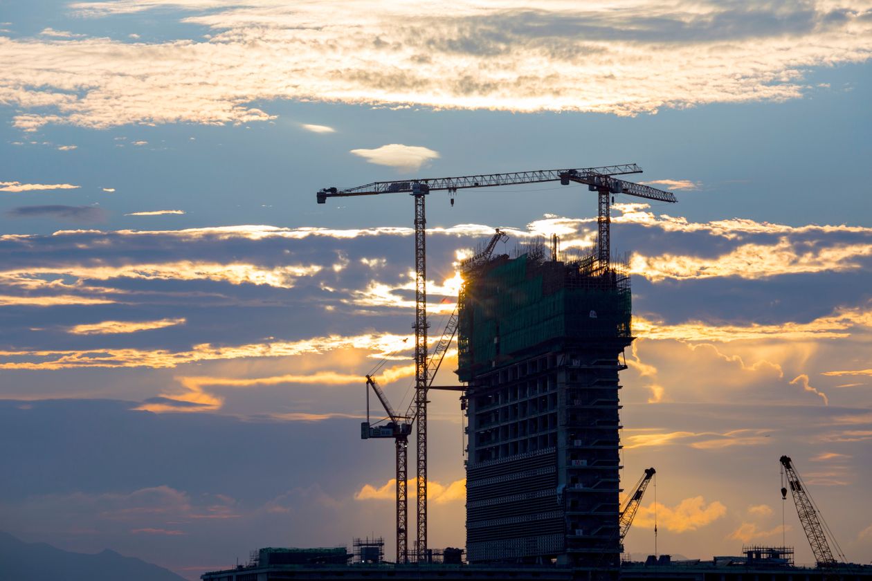 Multi-storey concrete building under construction with tower cranes - structural works standards for buildings