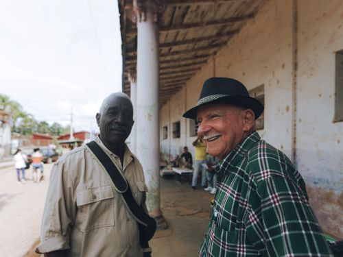 Free Two senior friends smiling and chatting on a vibrant street outdoors. Stock Photo