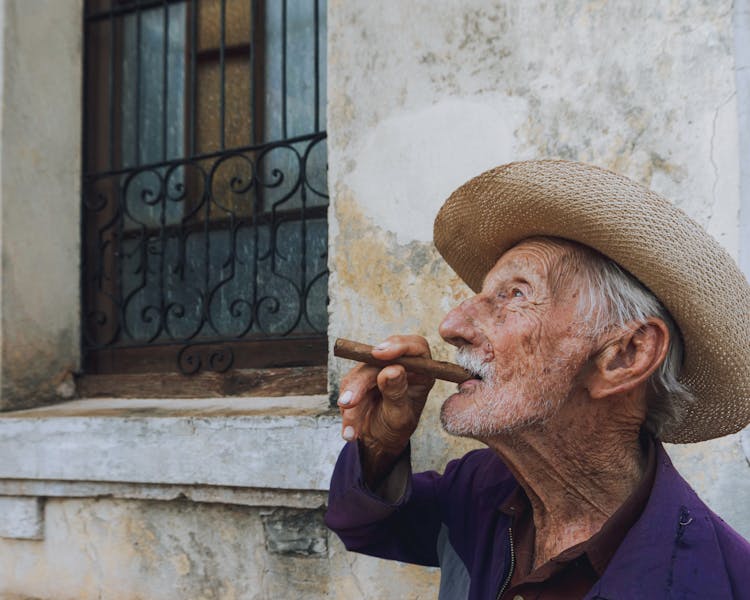 Man Wearing A Hat Smoking A Cigar