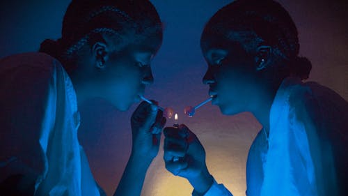 Women Holding Lighter Flame over Lollipops