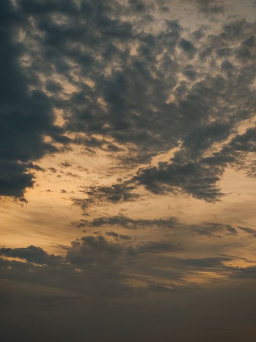 Free A captivating evening sky filled with dramatic gray clouds and subtle warm hues. Stock Photo