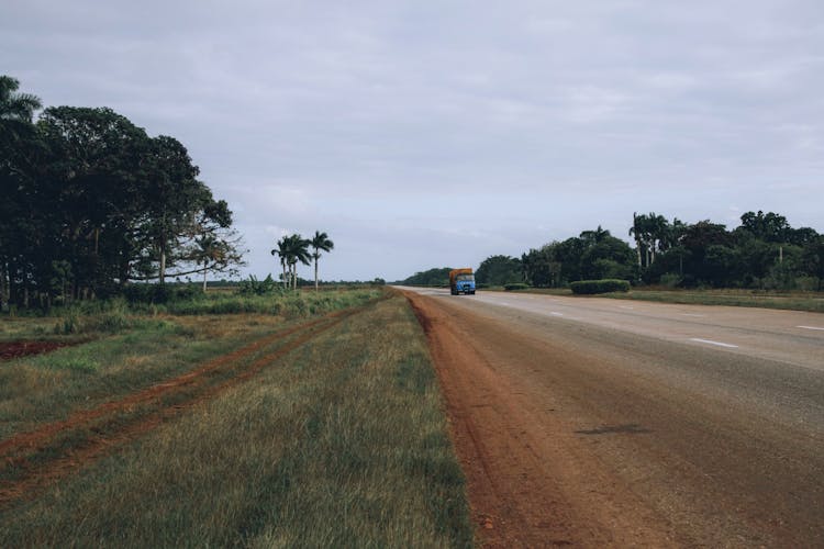 Blue Truck Driving Down The Road