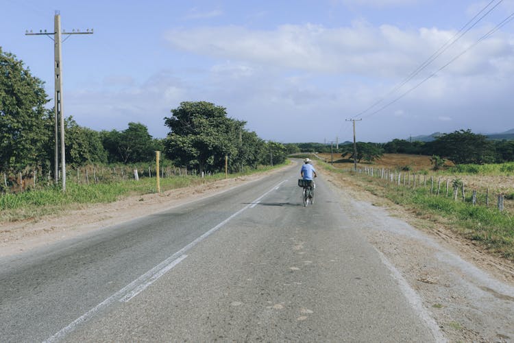 Man Riding A Bike On Asphalt Road