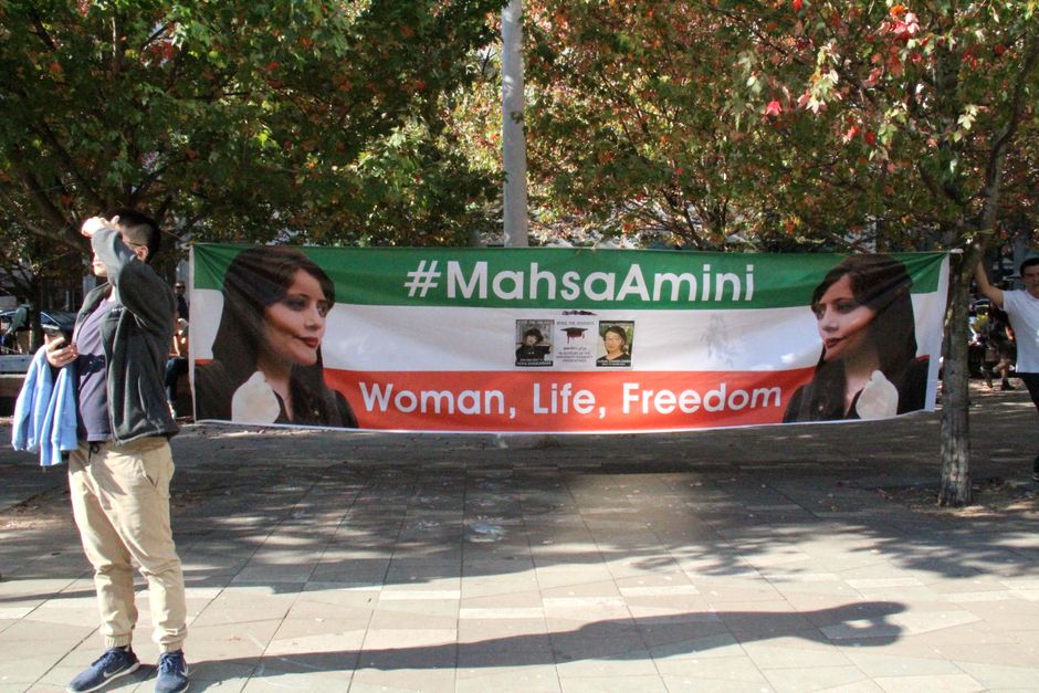Protest featuring a #MahsaAmini banner with 'Woman, Life, Freedom' in Vancouver.