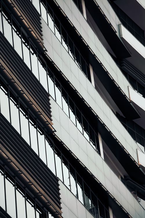 Free Vertical low-angle shot of a modern building facade in Mashhad with glass windows. Stock Photo