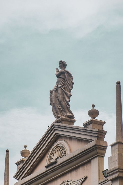 Free Elegant classical statue atop a historic building in Taguig, Philippines under a cloudy sky. Stock Photo