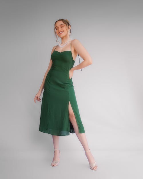 Woman in Green Spaghetti Strap Dress Posing with Hand on Waist