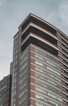 A modern skyscraper with glass facade showcasing contemporary architectural design against a clear sky.