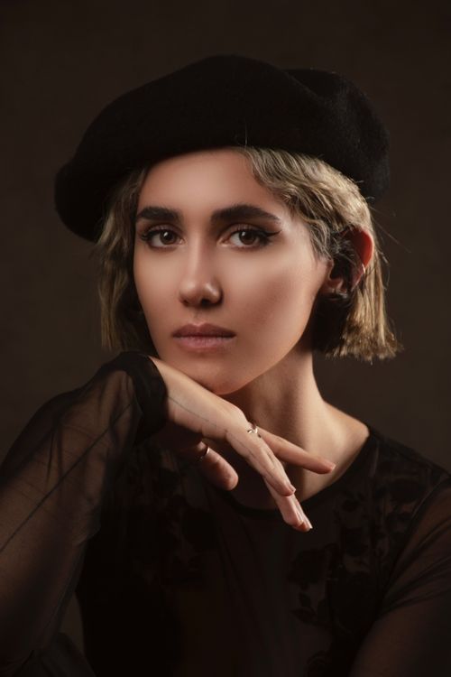 Free Stunning studio portrait of a woman in a black beret showing elegance and style. Stock Photo