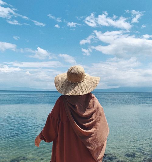 Free A woman stands by the sea in Bursa, Turkey, wearing a long dress and sunhat, enjoying the serene ocean view. Stock Photo