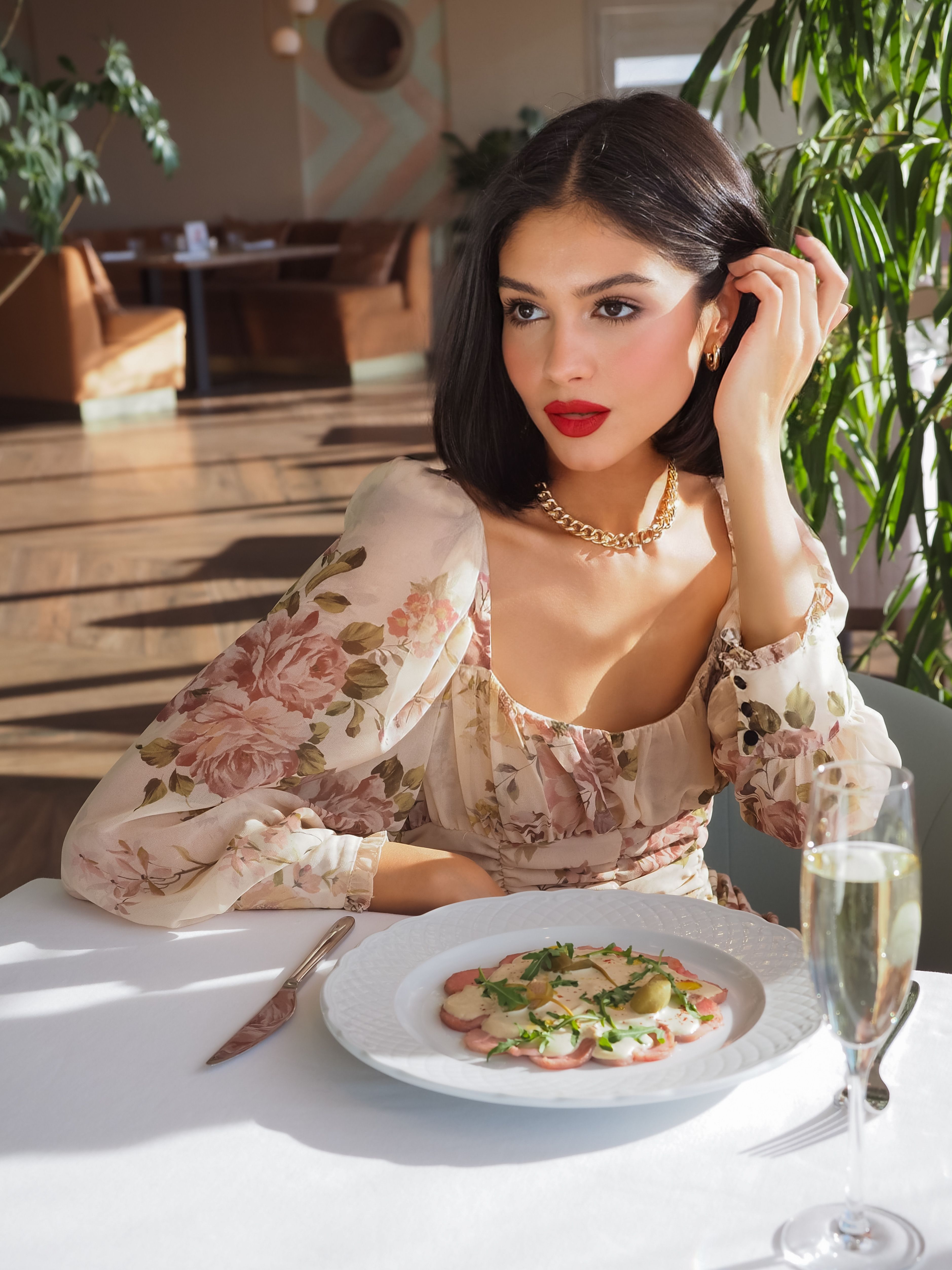 Woman in Floral Dress Sitting at White Table · Free Stock Photo