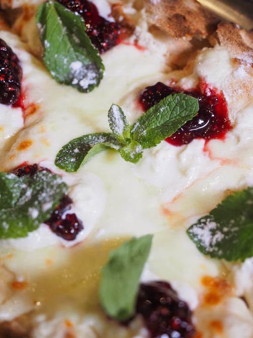 Free Indulge in a close-up view of a creamy raspberry dessert garnished with fresh mint leaves. Stock Photo