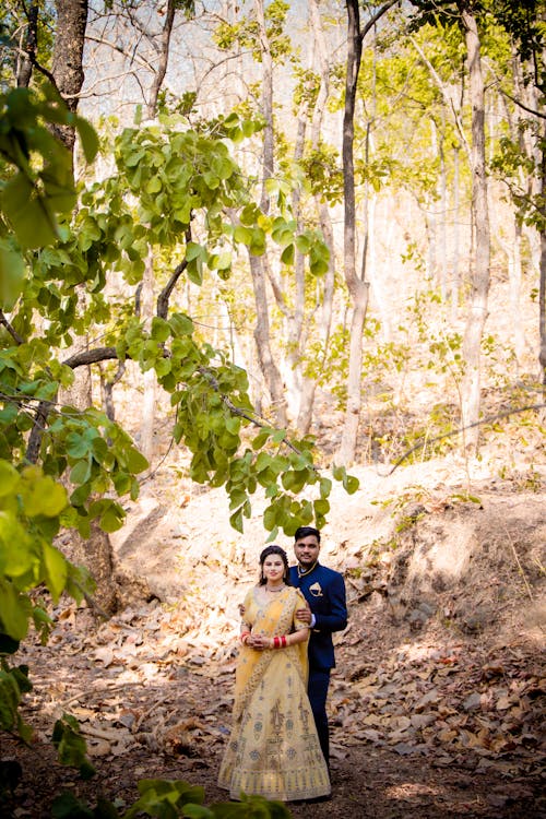 Bride and Groom in Wedding Dress Posing on Forest Walkway · Free