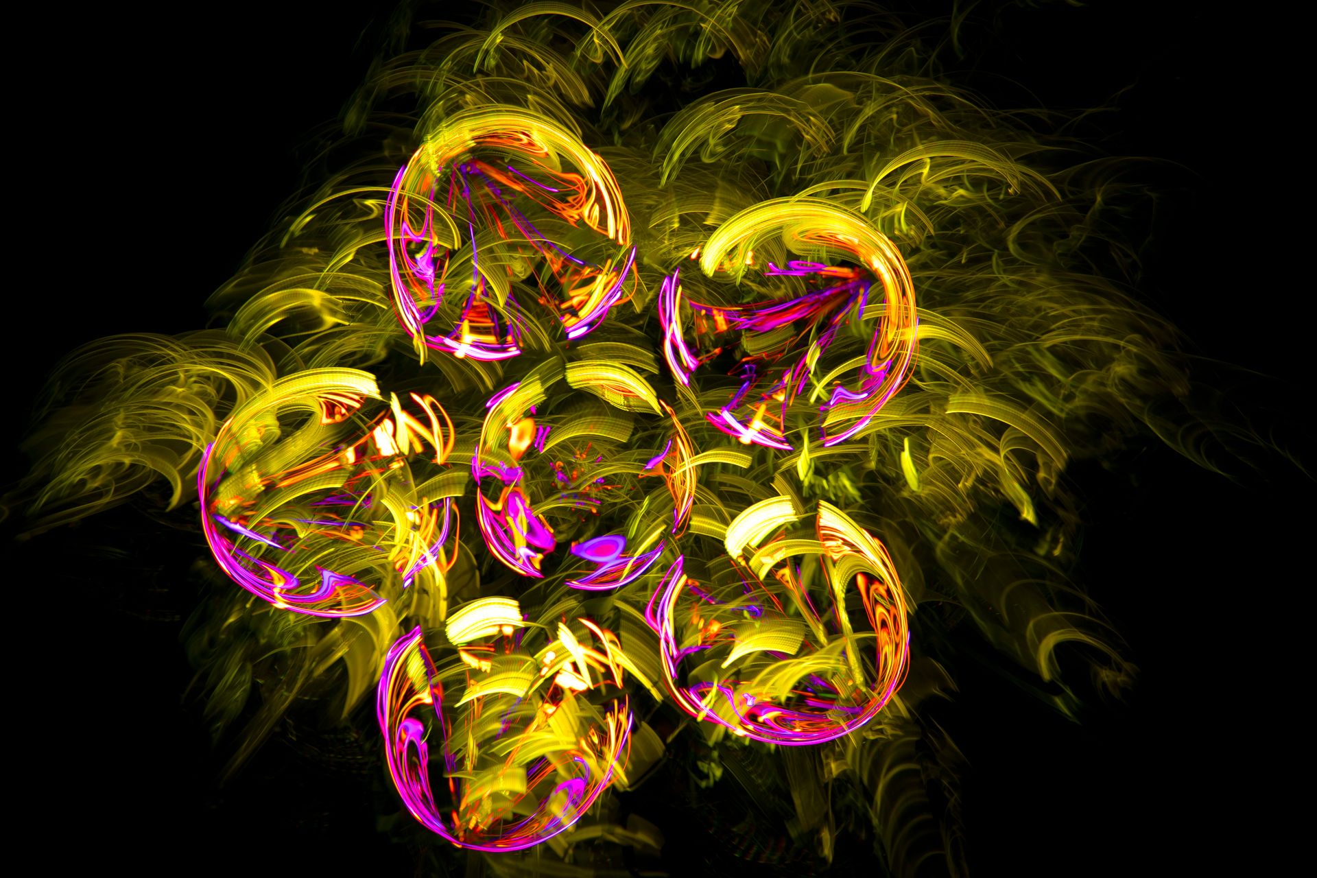 Stunning abstract light painting featuring vibrant yellow and purple circular shapes on a black background.
