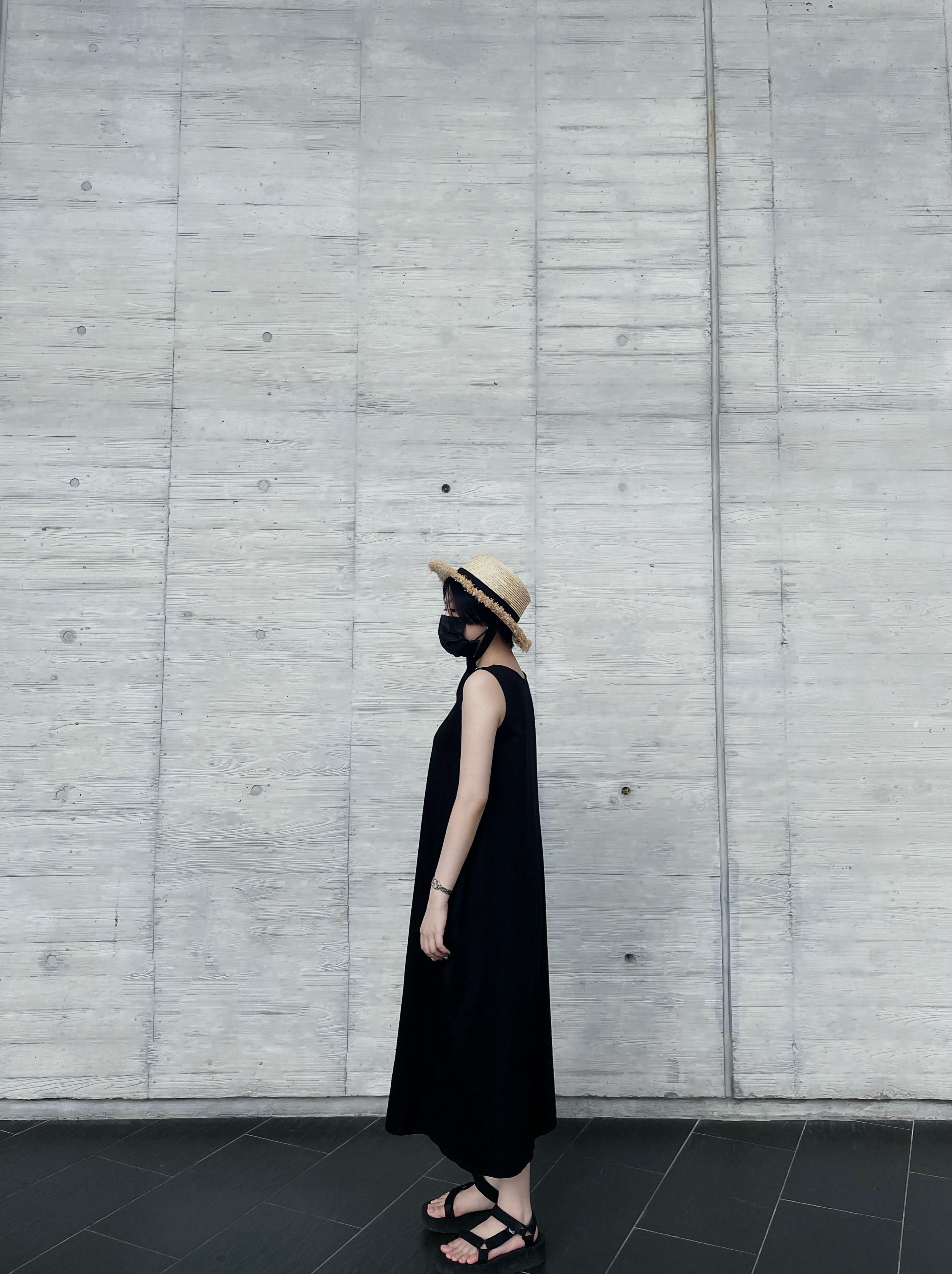Woman in Black Sleeveless Dress Standing Beside a Wall · Free Stock Photo
