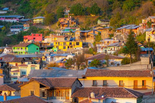Free A vibrant hillside town with colorful houses under warm daylight, showcasing diverse architecture. Stock Photo