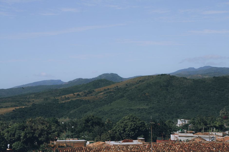 A serene view of green hills and distant mountains under a clear sky.