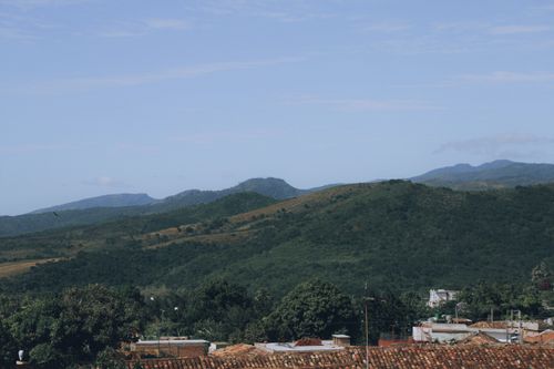 Free A serene view of green hills and distant mountains under a clear sky. Stock Photo