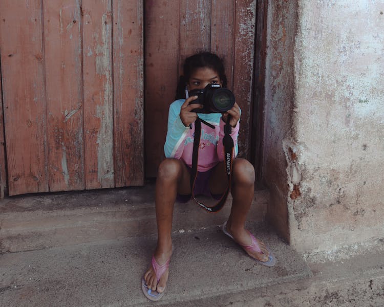 A Girl Holding A Black Digital Camera