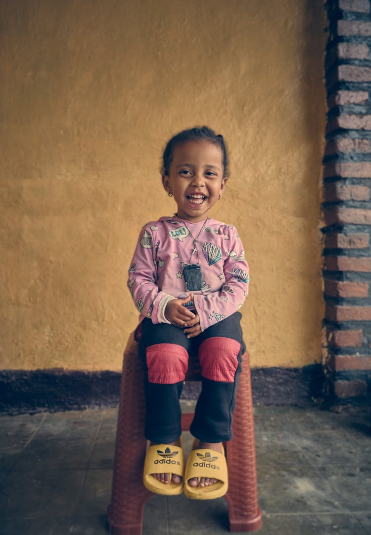 Little Girl Sitting On A Stool