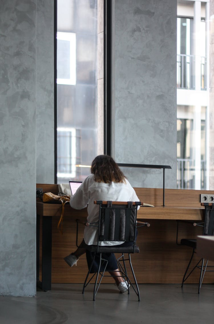 A Woman Sitting By A Desk 