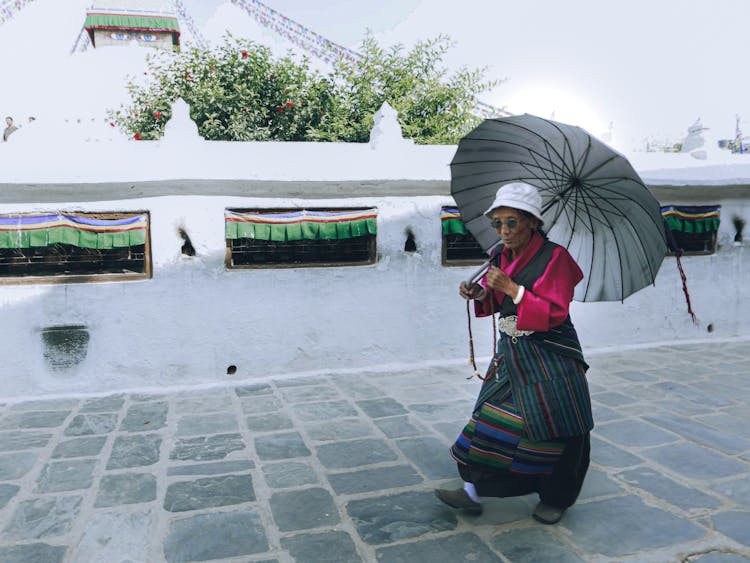 Walking Elderly Woman With An Umbrella