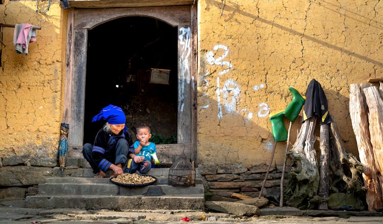 Woman And Young Boy Sitting On Stairs Eating