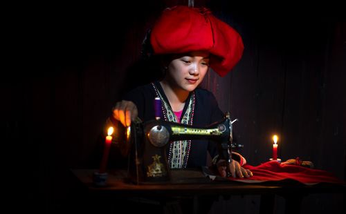 Free A Red Dao woman sewing by candlelight, showcasing Vietnamese culture and traditional attire. Stock Photo