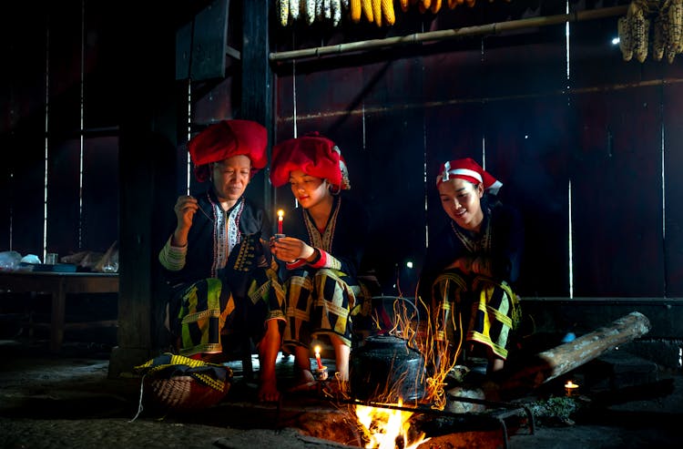 Red Dao Family Sitting In Dark Hut