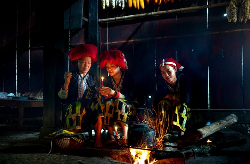 Free Red Dao hill tribe members gathered around a fire in traditional attire. Stock Photo