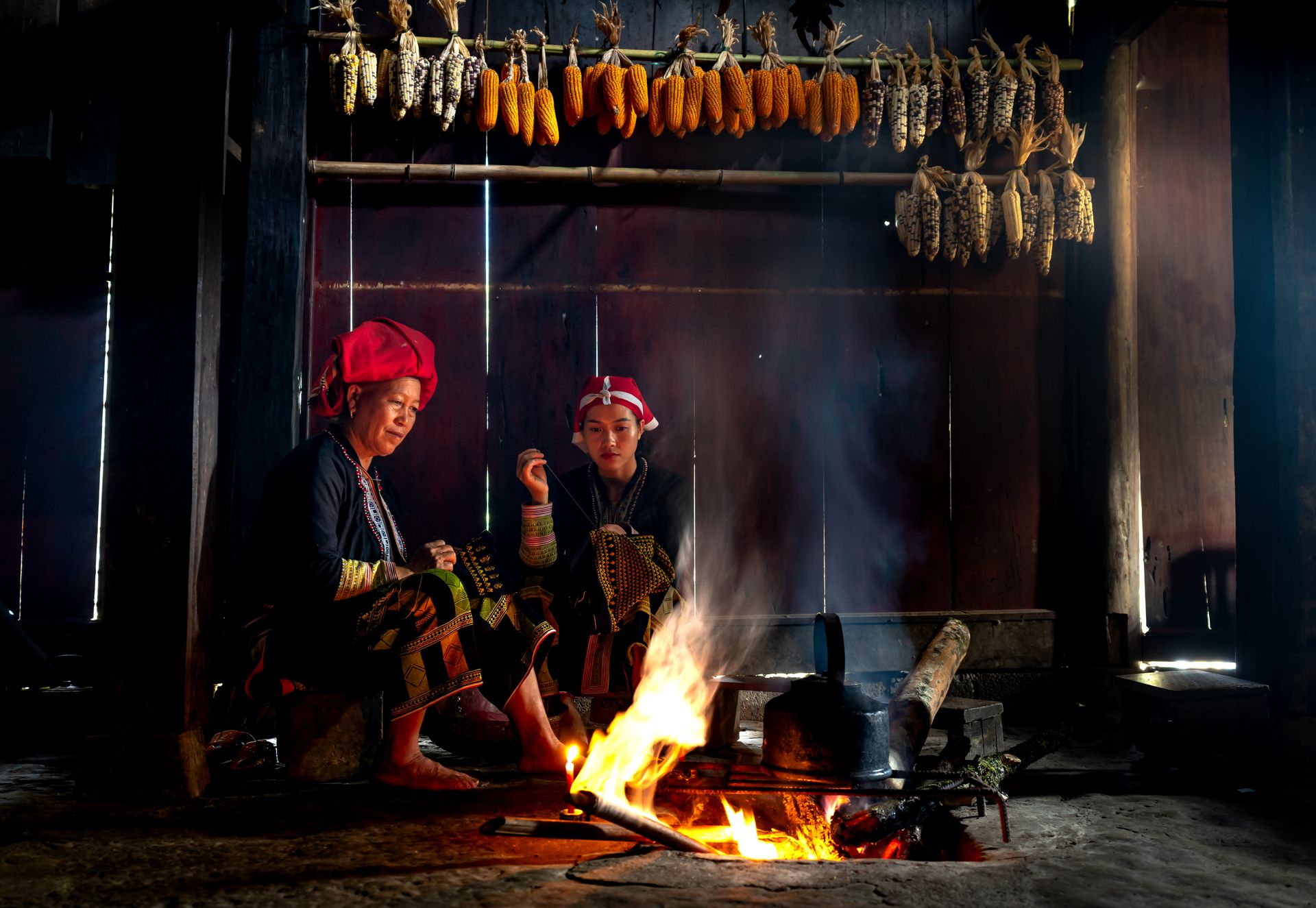 A warm scene of a family gathering around a hearth inside a traditional wooden cottage.