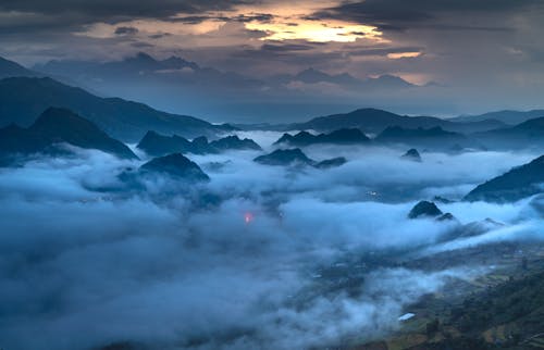 Mountain Peaks above Clouds at Sunset 