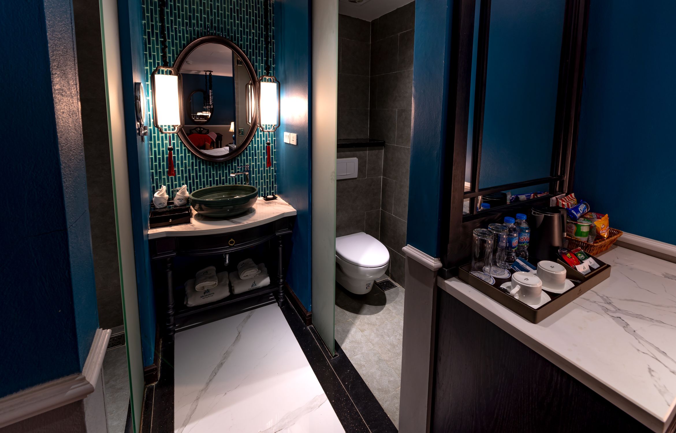 Stylish and modern hotel bathroom featuring chic blue walls and contemporary fixtures.